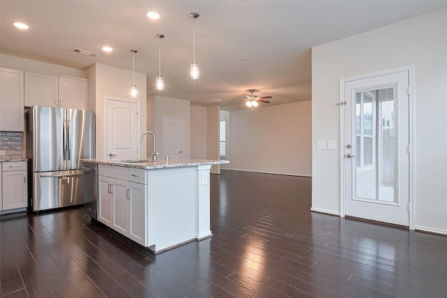 3414 Signor Dr, Houston, TX 77025 - kitchen with appliances with stainless steel finishes, dark wood finished floors, decorative backsplash, light stone countertops, and a ceiling fan