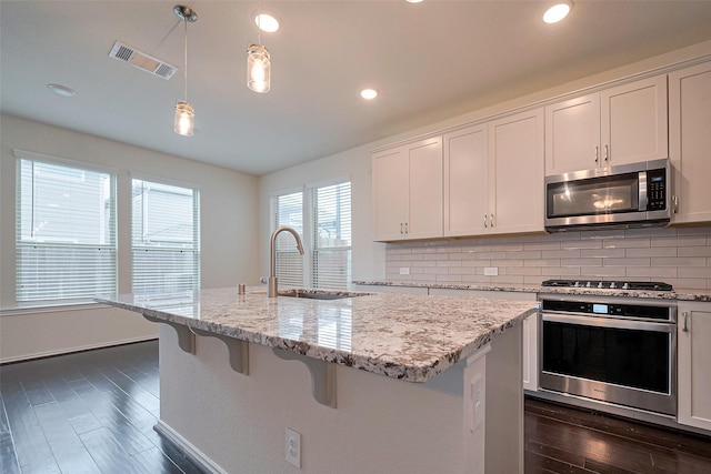3414 Signor Dr, Houston, TX 77025 - kitchen with stainless steel appliances, backsplash, dark wood-style flooring, light stone countertops, and recessed lighting