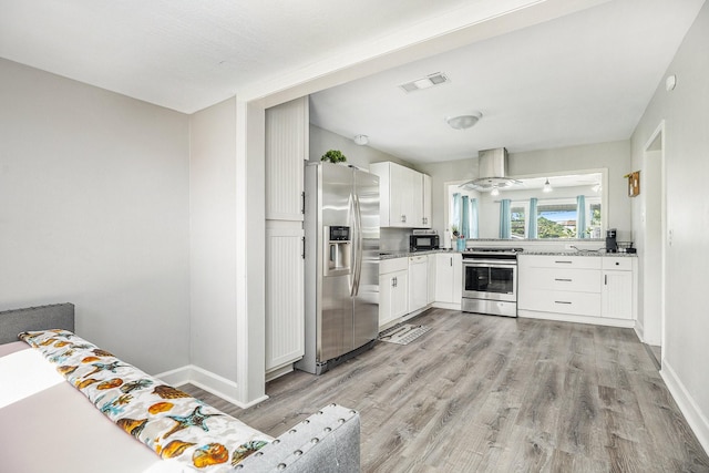 2315 67th St, Galveston, TX 77551 - kitchen with appliances with stainless steel finishes, island exhaust hood, light wood-style floors, and white cabinets