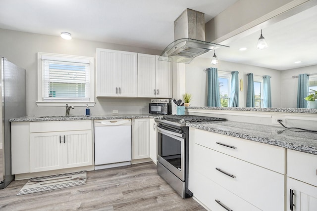 2315 67th St, Galveston, TX 77551 - kitchen featuring stainless steel appliances, ventilation hood, plenty of natural light, light stone countertops, and recessed lighting