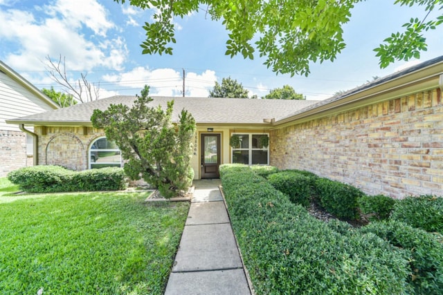 15806 Pfeiffer Dr, Houston, TX 77082 - doorway to property with a yard, roof with shingles, and brick siding