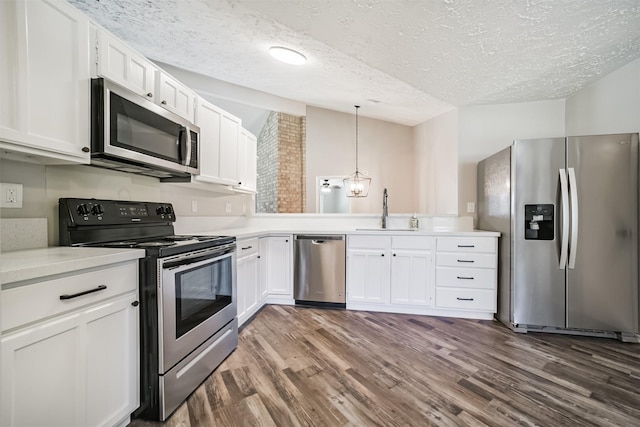 15806 Pfeiffer Dr, Houston, TX 77082 - kitchen featuring stainless steel appliances, dark wood-type flooring, a textured ceiling, light countertops, and white cabinetry