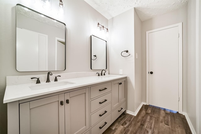 15806 Pfeiffer Dr, Houston, TX 77082 - bathroom featuring double vanity, wood finished floors, and a textured ceiling