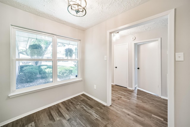 15806 Pfeiffer Dr, Houston, TX 77082 - unfurnished room featuring a textured ceiling, dark wood-style flooring, and a chandelier