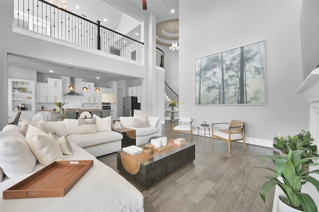 33 Violet Sunset Ln, Tomball, TX 77375 - living area featuring a towering ceiling, light wood-type flooring, stairway, and a chandelier