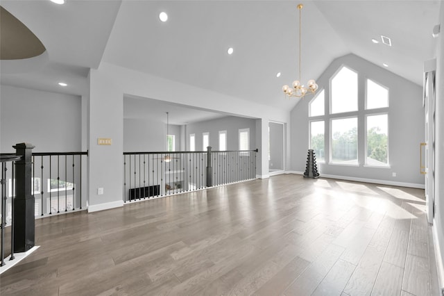 33 Violet Sunset Ln, Tomball, TX 77375 - unfurnished living room with a chandelier, wood finished floors, high vaulted ceiling, and recessed lighting
