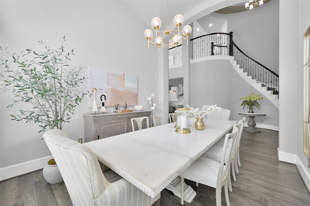 33 Violet Sunset Ln, Tomball, TX 77375 - dining room featuring a chandelier, a towering ceiling, wood finished floors, and stairway
