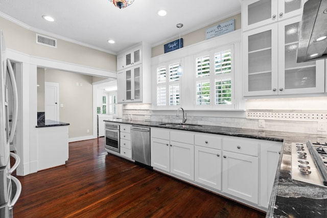 603 Hardeman St, Sealy, TX 77474 - kitchen with appliances with stainless steel finishes, crown molding, white cabinets, dark stone counters, and dark wood-style flooring