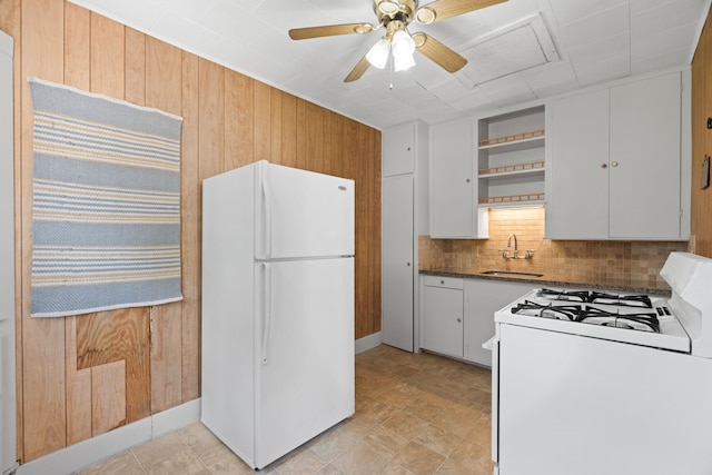 603 Hardeman St, Sealy, TX 77474 - kitchen with white appliances, open shelves, wooden walls, white cabinets, and decorative backsplash