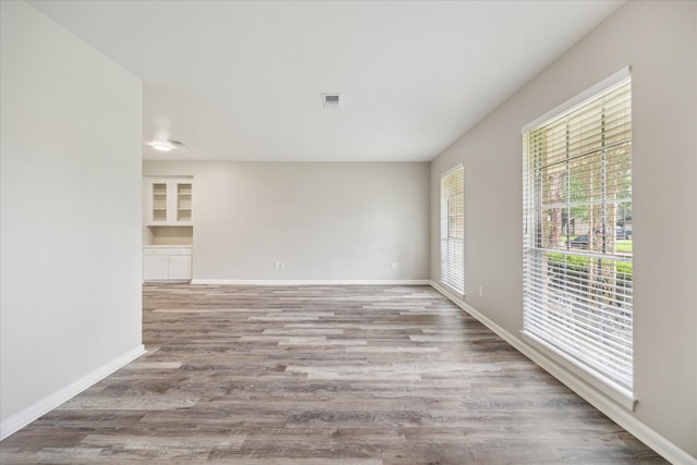 8210 Morley St, Houston, TX 77061 - spare room featuring healthy amount of natural light, wood finished floors, and built in shelves