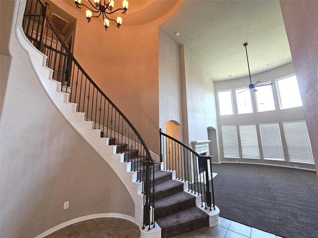 3811 Pearl Pass Ln, Sugar Land, TX 77479 - staircase featuring a towering ceiling, carpet floors, tile patterned flooring, a chandelier, and a ceiling fan
