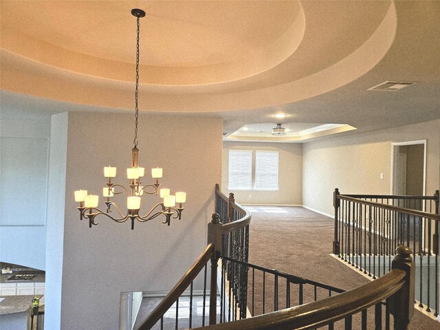 3811 Pearl Pass Ln, Sugar Land, TX 77479 - stairway featuring a tray ceiling, a chandelier, and carpet floors
