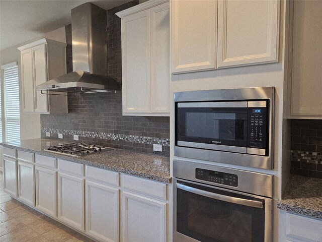 3811 Pearl Pass Ln, Sugar Land, TX 77479 - kitchen featuring stainless steel appliances, wall chimney exhaust hood, backsplash, and white cabinets