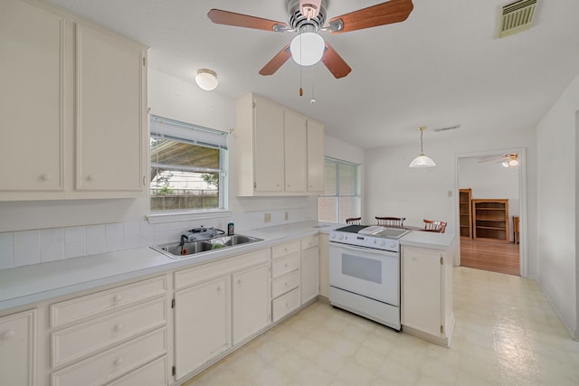 5006 Hazelton St, Houston, TX 77035 - kitchen featuring white range with electric cooktop, light floors, a ceiling fan, a peninsula, and light countertops