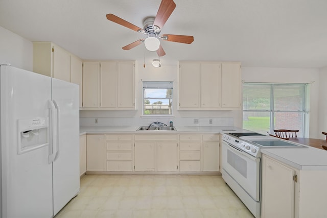 5006 Hazelton St, Houston, TX 77035 - kitchen with white appliances, a peninsula, light floors, and cream cabinets