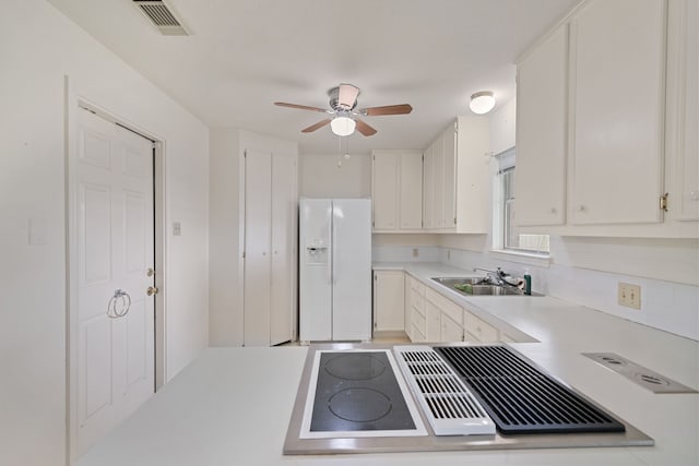 5006 Hazelton St, Houston, TX 77035 - kitchen featuring white refrigerator with ice dispenser, stovetop with downdraft, ceiling fan, light countertops, and white cabinets
