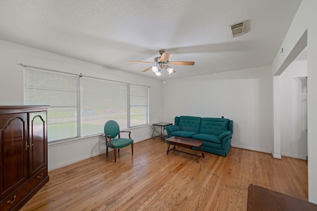 5006 Hazelton St, Houston, TX 77035 - living area with light wood-style floors, ceiling fan, and a textured ceiling