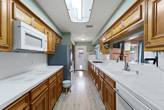 11614 Brighton Ln, Meadows Place, TX 77477 - kitchen with appliances with stainless steel finishes, brown cabinets, and tile countertops