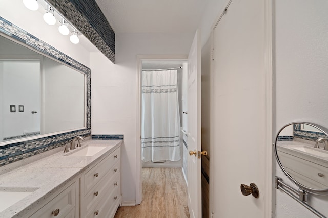 11614 Brighton Ln, Meadows Place, TX 77477 - bathroom featuring double vanity, a shower with curtain, and wood finished floors