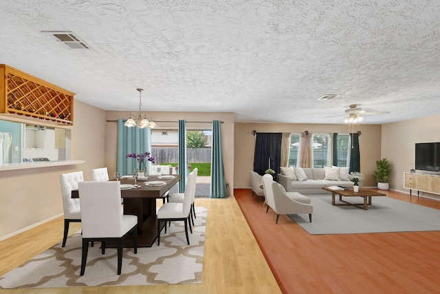 11614 Brighton Ln, Meadows Place, TX 77477 - dining room with plenty of natural light, wood finished floors, a chandelier, a ceiling fan, and a textured ceiling