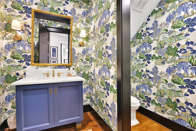 811 Byrne St, Houston, TX 77009 - bathroom with vanity, wallpapered walls, and wood finished floors