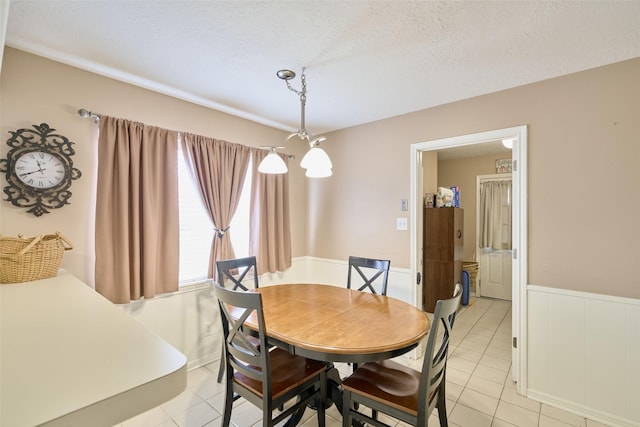 15402 Ripplestream, Houston, TX 77068 - dining space featuring light tile patterned flooring, a textured ceiling, and a wainscoted wall
