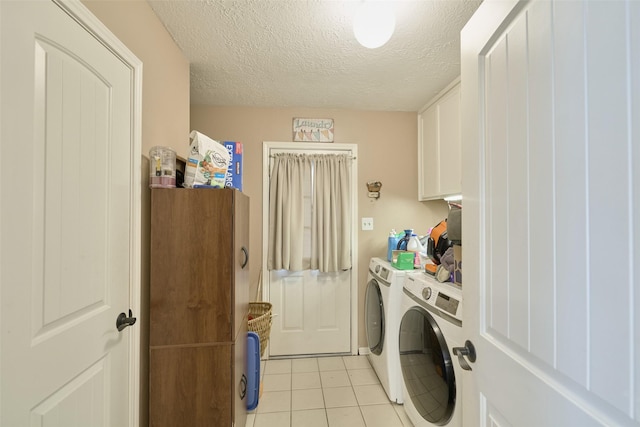 15402 Ripplestream, Houston, TX 77068 - laundry area featuring washing machine and clothes dryer, cabinet space, light tile patterned flooring, and a textured ceiling
