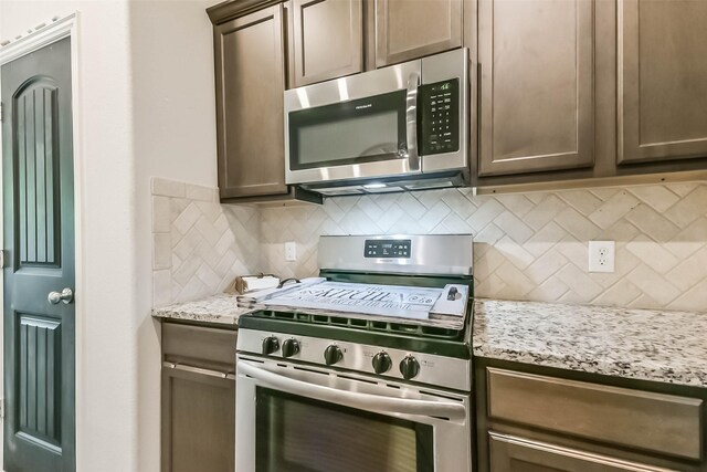 16107 Dockside St, Crosby, TX 77532 - kitchen with appliances with stainless steel finishes, backsplash, and light stone counters