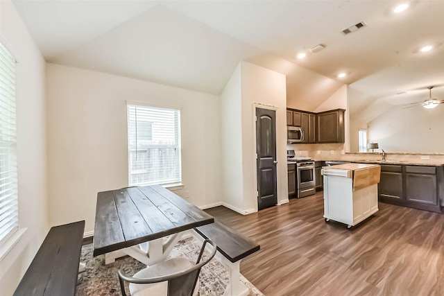 16107 Dockside St, Crosby, TX 77532 - kitchen with stainless steel appliances, light countertops, lofted ceiling, dark wood finished floors, and a kitchen island