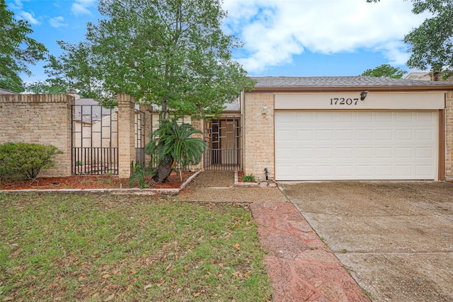 17207 Meadow Butte Dr, Houston, TX 77090 - view of front of house with concrete driveway, a garage, a gate, brick siding, and a shingled roof
