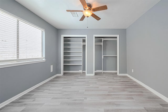 17207 Meadow Butte Dr, Houston, TX 77090 - unfurnished bedroom featuring multiple closets, light wood-style floors, and ceiling fan