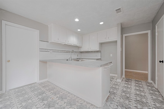 17207 Meadow Butte Dr, Houston, TX 77090 - kitchen featuring light countertops, a peninsula, white cabinets, recessed lighting, and decorative backsplash