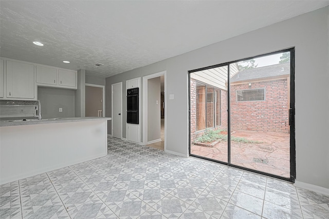 17207 Meadow Butte Dr, Houston, TX 77090 - kitchen featuring light countertops, black oven, recessed lighting, a warming drawer, and a textured ceiling