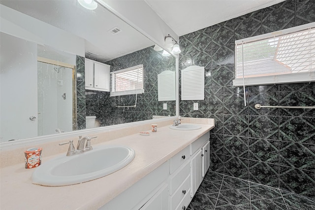 17207 Meadow Butte Dr, Houston, TX 77090 - bathroom featuring double vanity, a walk in shower, and tile walls