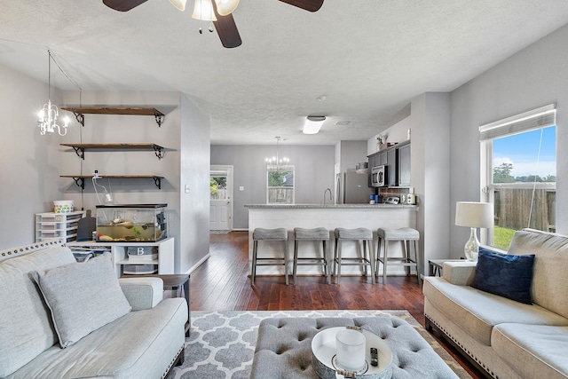 454 Fishhawk Way, Crosby, TX 77532 - living room featuring a chandelier, ceiling fan, dark wood finished floors, healthy amount of natural light, and a textured ceiling
