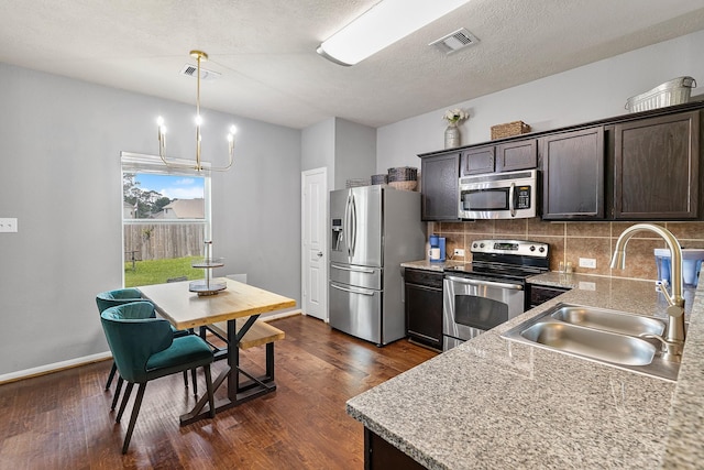 454 Fishhawk Way, Crosby, TX 77532 - kitchen featuring appliances with stainless steel finishes, dark brown cabinetry, tasteful backsplash, dark wood-type flooring, and a textured ceiling