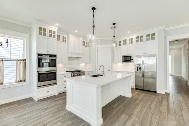 3806 Abalone Rd, Galveston, TX 77554 - kitchen with appliances with stainless steel finishes, crown molding, decorative backsplash, light countertops, and a kitchen island with sink