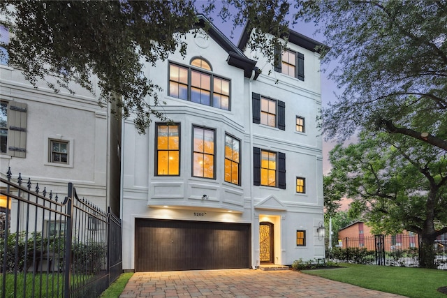 5200 Jackson St, Houston, TX 77004 - view of front of house featuring an attached garage, stucco siding, and decorative driveway