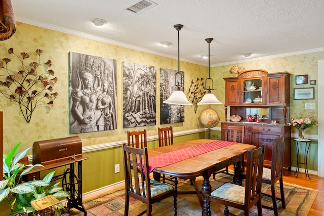 5022 Briarbend Dr, Houston, TX 77035 - dining space with wallpapered walls, wood finished floors, a textured ceiling, and ornamental molding