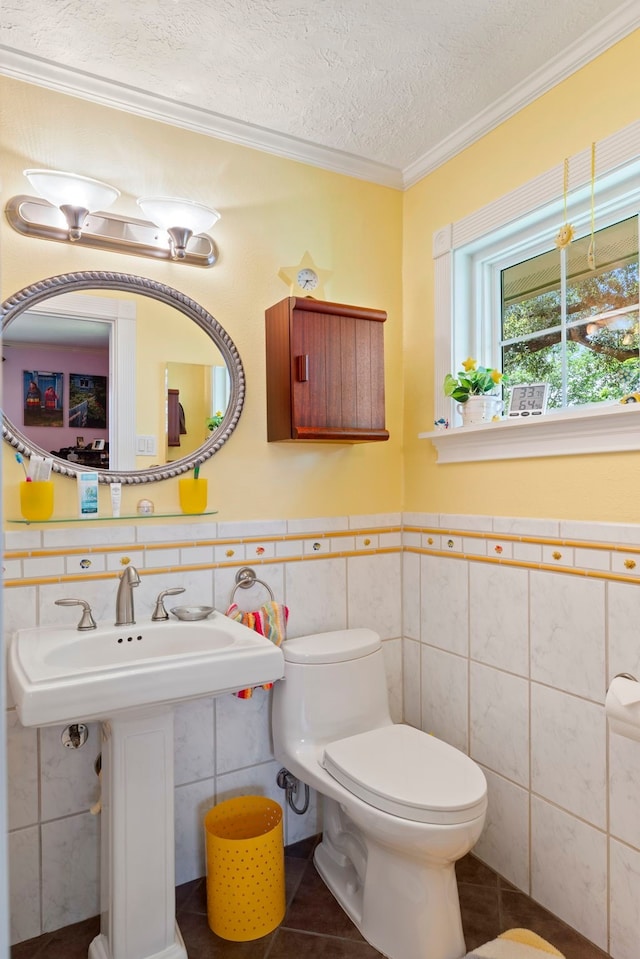 5022 Briarbend Dr, Houston, TX 77035 - bathroom with tile walls, tile patterned flooring, a textured ceiling, crown molding, and a wainscoted wall