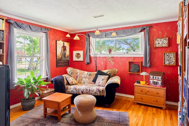 5022 Briarbend Dr, Houston, TX 77035 - living room featuring healthy amount of natural light, wood finished floors, a textured ceiling, ornamental molding, and wallpapered walls