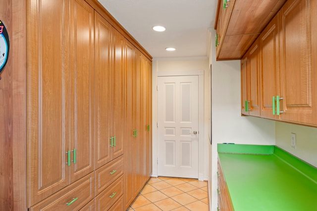 5022 Briarbend Dr, Houston, TX 77035 - kitchen with light tile patterned floors, recessed lighting, crown molding, and brown cabinets