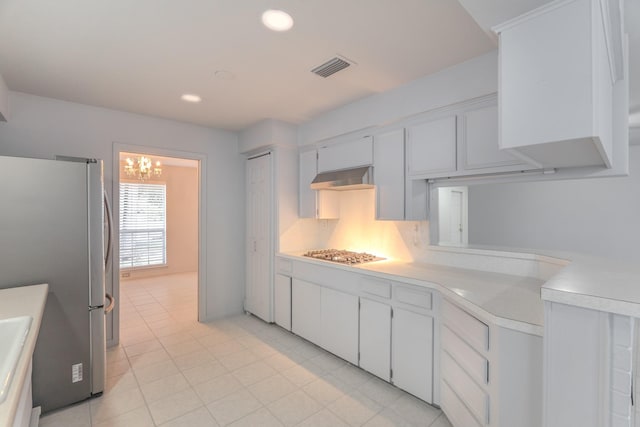 3906 Antoine Dr, Houston, TX 77092 - kitchen featuring stainless steel appliances, light countertops, exhaust hood, white cabinets, and light tile patterned flooring