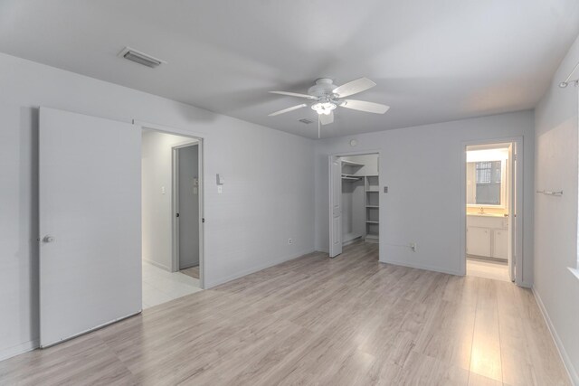 3906 Antoine Dr, Houston, TX 77092 - unfurnished bedroom featuring light wood-style floors, connected bathroom, a ceiling fan, a spacious closet, and a closet