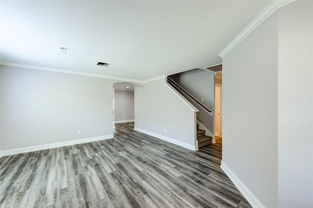 1810 Adobe Stone Dr, Humble, TX 77396 - unfurnished living room with arched walkways, crown molding, wood finished floors, and stairway