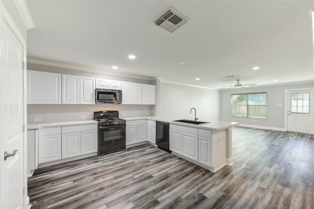 1810 Adobe Stone Dr, Humble, TX 77396 - kitchen featuring black appliances, crown molding, a peninsula, recessed lighting, and white cabinetry