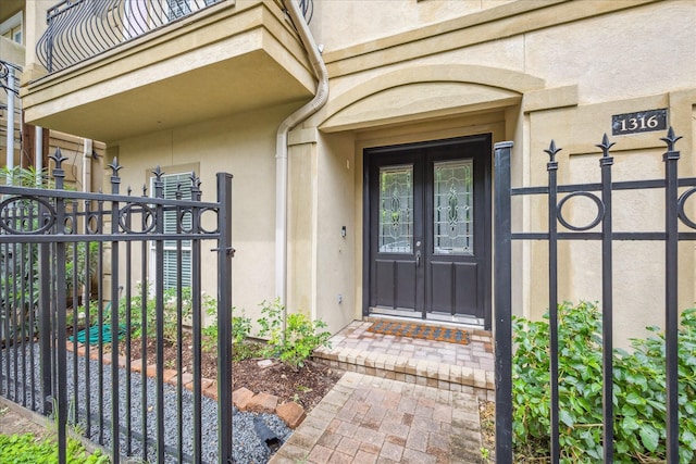 1316 Birdsall St, Houston, TX 77007 - view of exterior entry with stucco siding, a gate, and french doors