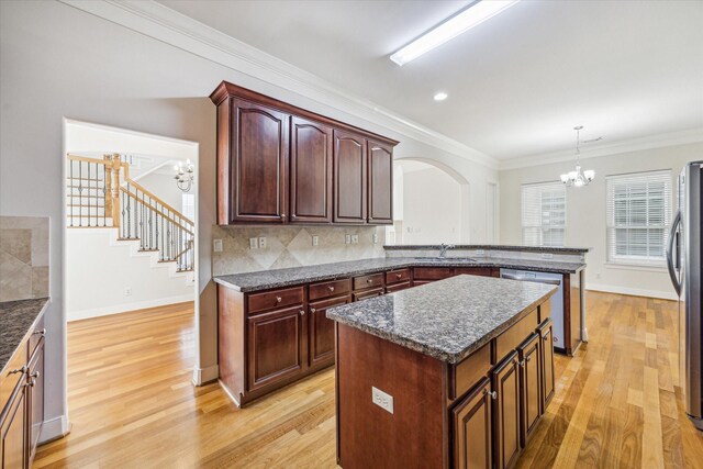 1316 Birdsall St, Houston, TX 77007 - kitchen with a chandelier, stainless steel appliances, light wood finished floors, arched walkways, and ornamental molding
