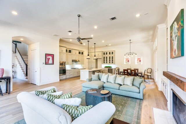 6114 Cottage Grove Lake Dr, Houston, TX 77007 - living room with ornamental molding, light wood-style flooring, stairs, a ceiling fan, and recessed lighting