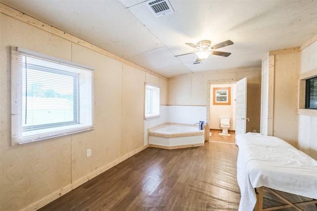 7528 Gainesville St, Houston, TX 77020 - unfurnished bedroom featuring dark wood-type flooring, connected bathroom, and a ceiling fan